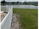 Scenic view of a pond with manicured lawn and white fence at 5940 21St N St # 11, St Petersburg, FL 33714