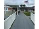 A walkway lined with a white fence leading to a recreation hall at 5940 21St N St # 11, St Petersburg, FL 33714