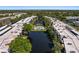Aerial view showcasing the community layout with a central lake, swimming pool and meticulously manicured landscaping at 6070 80Th N St # 308, St Petersburg, FL 33709