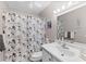 Well-lit bathroom with floral shower curtain and a vanity with ample lighting at 6070 80Th N St # 308, St Petersburg, FL 33709