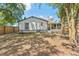 Backyard view with a white home, spacious yard, and mature trees at 6204 Nebraska Ave, New Port Richey, FL 34653
