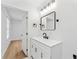 Updated bathroom with black fixtures, white vanity, and open door to bedroom at 6204 Nebraska Ave, New Port Richey, FL 34653