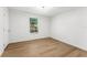 Neutral bedroom with wood floors and window to trees at 6204 Nebraska Ave, New Port Richey, FL 34653