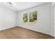 Bright bedroom with wood-look flooring and a large window offering natural light at 6204 Nebraska Ave, New Port Richey, FL 34653