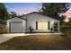 Inviting exterior of a home featuring fresh paint, modern lighting, and an attached garage at 6204 Nebraska Ave, New Port Richey, FL 34653