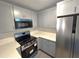 Bright kitchen features gray cabinets, stone countertops, and stainless steel appliances at 6204 Nebraska Ave, New Port Richey, FL 34653