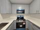 Updated kitchen features gray cabinets, stone countertops, and stainless steel appliances at 6204 Nebraska Ave, New Port Richey, FL 34653