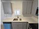 Updated kitchen features stone countertops, stainless steel sink, and gray cabinets at 6204 Nebraska Ave, New Port Richey, FL 34653