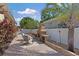 Backyard paver patio with a brick fireplace, fence, tropical plants and outdoor seating at 7410 S Fitzgerald St, Tampa, FL 33616