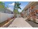 Paver patio with privacy fence, tropical landscaping and outdoor seating at 7410 S Fitzgerald St, Tampa, FL 33616