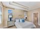 Well-lit bedroom with tray ceiling, two windows, and elegant decor at 7410 S Fitzgerald St, Tampa, FL 33616