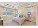 Serene bedroom with tray ceiling, large windows, and coordinating nightstands at 7410 S Fitzgerald St, Tampa, FL 33616