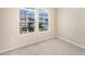 Bright carpeted bedroom with a view of the neighborhood through a double window at 7410 S Fitzgerald St, Tampa, FL 33616