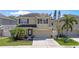 Charming two-story home with a well-manicured lawn, beautiful palm trees, and a spacious driveway at 7410 S Fitzgerald St, Tampa, FL 33616