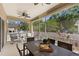 Screened-in patio area with comfortable seating, a ceiling fan, and outdoor dining space at 7410 S Fitzgerald St, Tampa, FL 33616