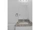 Powder room with granite sink, toilet, and modern fixtures at 7603 Rhode Island Dr, Tampa, FL 33619