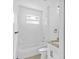 Bright bathroom features tile floors, marble tile walls, a toilet, and tub with shower at 7603 Rhode Island Dr, Tampa, FL 33619