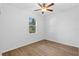 Comfortable bedroom with a ceiling fan, a bright window, and wood-style flooring at 7603 Rhode Island Dr, Tampa, FL 33619