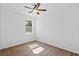 Bedroom with neutral walls features wood floors, a ceiling fan and a window at 7603 Rhode Island Dr, Tampa, FL 33619