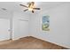Bedroom with neutral walls features wood floors, a ceiling fan, window, and closet at 7603 Rhode Island Dr, Tampa, FL 33619