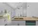 Modern kitchen island with granite countertops and stainless steel sink overlooks the living area at 7603 Rhode Island Dr, Tampa, FL 33619