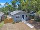 Aerial view of a gray home featuring a well-maintained yard and a charming blue front door at 8114 N 11Th St, Tampa, FL 33604