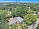 An aerial view shows the property nestled among mature trees, and nearby stadium in the distance at 8114 N 11Th St, Tampa, FL 33604