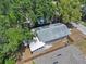 An aerial view of the cozy home showing the layout, new gray roof, and the surrounding lush trees at 8114 N 11Th St, Tampa, FL 33604