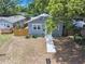 A high angle shot of a light gray house with a blue door and a fenced in yard on a sunny day at 8114 N 11Th St, Tampa, FL 33604