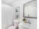 A clean bathroom featuring a sink, toilet, and shower curtain with decorative artwork at 8114 N 11Th St, Tampa, FL 33604