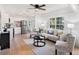 Open-concept living area with a view into the kitchen, featuring stylish furniture and hardwood floors at 8114 N 11Th St, Tampa, FL 33604