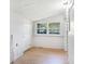 Light-filled room with white trim, door, and wood-look floors at 8114 N 11Th St, Tampa, FL 33604