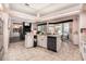 Open kitchen with tile floors, island sink, and views to the breakfast area and living room with fireplace at 8406 Glengarry Pl, Trinity, FL 34655