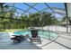 A view of the pool and spa, along with comfortable lounge seating, in a screen enclosure at 8406 Glengarry Pl, Trinity, FL 34655