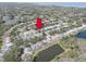 Aerial view featuring the community with mature trees and landscaping near tranquil lakes and a golf course at 1069 Captains Way, Tarpon Springs, FL 34689