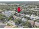 Enjoy the aerial view of a home with a lush, tree-filled neighborhood near a tranquil lake at 1069 Captains Way, Tarpon Springs, FL 34689