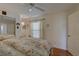 Comfortable bedroom featuring floral bedding, a ceiling fan, and a reading nook at 1069 Captains Way, Tarpon Springs, FL 34689