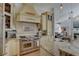 Kitchen with stainless steel oven and range hood and cream colored cabinets at 1069 Captains Way, Tarpon Springs, FL 34689
