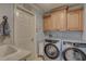 Functional laundry room with modern washer and dryer units, overhead cabinets, and sink at 1069 Captains Way, Tarpon Springs, FL 34689