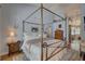 Comfortable bedroom with a four-poster bed, hardwood floors, and soft, neutral colors at 1069 Captains Way, Tarpon Springs, FL 34689