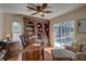 Well-lit home office featuring a desk, bookshelves, chair, and view of the screened-in pool at 1069 Captains Way, Tarpon Springs, FL 34689