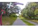 The long pathway leading up to Tarpon Springs is lined with green foliage and trees at 1069 Captains Way, Tarpon Springs, FL 34689