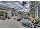 Spacious screened-in pool area with lounge chairs, seating, and a view of the backyard at 1069 Captains Way, Tarpon Springs, FL 34689
