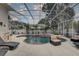 Inviting screened-in pool area with lounge chairs, seating, and a view of the backyard at 1069 Captains Way, Tarpon Springs, FL 34689