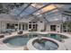 Inviting outdoor pool area featuring a spa, ample seating, and a screened enclosure at 1069 Captains Way, Tarpon Springs, FL 34689