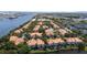 Aerial view showcases the waterfront condos, lush greenery, and serene waterways with industrial backdrop at 1117 Shipwatch Cir, Tampa, FL 33602