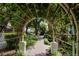 Landscaped walkway featuring lush vegetation, a trellis, manicured lawns, and beautiful trees at 1117 Shipwatch Cir, Tampa, FL 33602