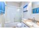 Bright bathroom featuring a shower-tub combo with sliding glass doors and a stylish vanity at 11427 Laurel Brook Ct, Riverview, FL 33569