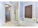 A spacious bathroom featuring a bathtub and a glass enclosed shower at 11427 Laurel Brook Ct, Riverview, FL 33569