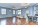 Open floor plan living room features wood floors, a ceiling fan and natural light at 11427 Laurel Brook Ct, Riverview, FL 33569